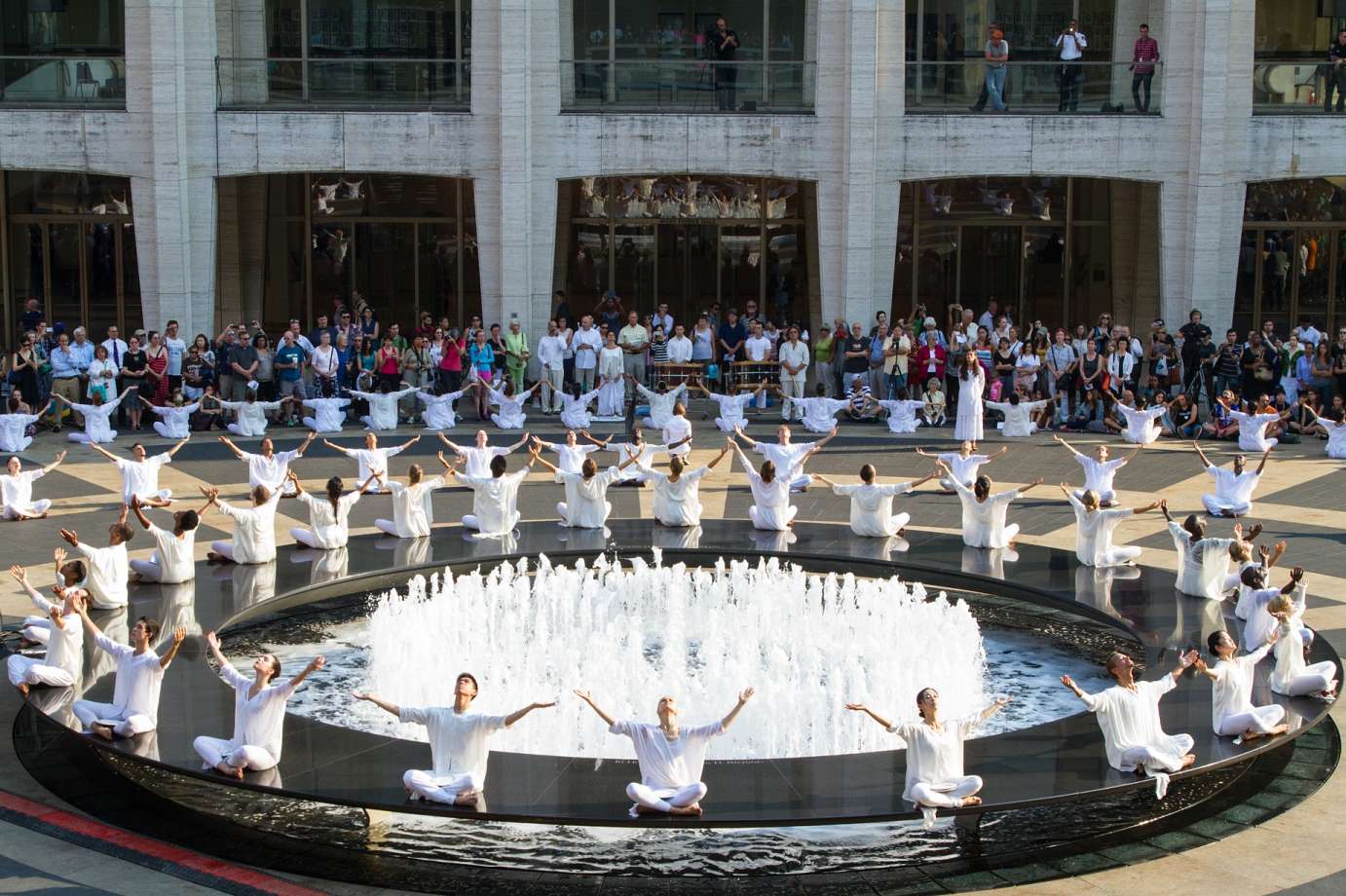 Dancers dressed in white surround Lincoln Center's Revron Fountain during the Table of Silence